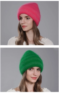 Detailed knit texture of warm winter rabbit fur beanie in vibrant pink and green