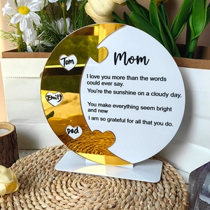 Macro detail of acrylic Mom puzzle sign with customized heart names and golden mirror finish