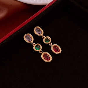 Detailed macro view of vintage oval zircon drop earrings with purple, green, and red stones