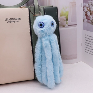 Cute blue plush octopus keychain with large eyes hanging on a stylish handbag