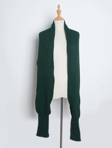 Detail view of dark green knitted shawl scarf with sleeves on a mannequin torso