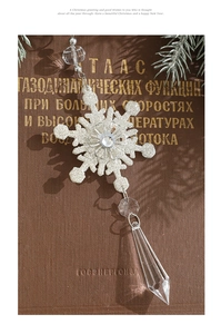 Detailed view of white glitter Christmas snowflake ornament with acrylic crystal drop
