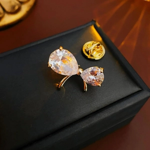 Close-up of gold-plated butterfly brooch with pear-shaped zircon on black jewelry box