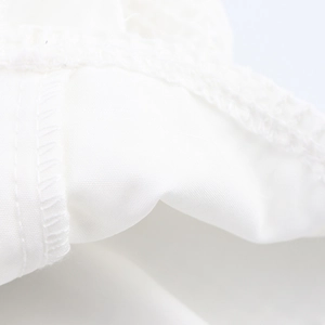 Détail macro de la texture du tissu blanc et des coutures de précision pour le haut court