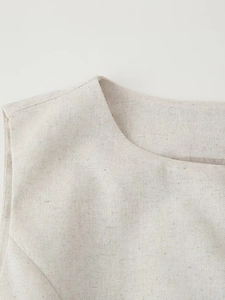 Detailed close-up of the round neckline and linen texture on a beige vest for women