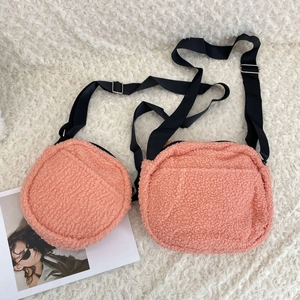 Detail of plush lamb wool crossbody bags with adjustable straps in pink coral
