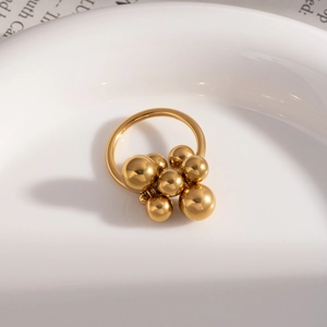 French vintage gold bead adjustable open ring displayed on a white porcelain plate