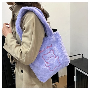 Détail d'un sac cabas en peluche violette avec broderie ours sur manteau beige