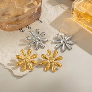 Macro view of gold and silver flower stud earrings on textured lifestyle background