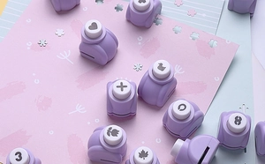 Macro shot of purple mini craft punches and cut-out patterns on pastel color paper