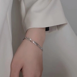 Minimalist silver Figaro chain bracelet in stainless steel worn on a model wrist