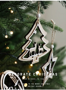 Close-up of wooden Christmas tree ornament with reindeer silhouette on a pine branch