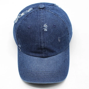 Dettaglio del cappello da baseball in denim lavato con fori consumati e stile vintage