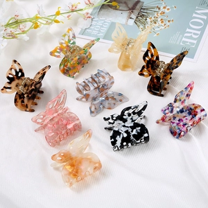 Detailed macro view of nine butterfly-shaped resin hair clips in assorted colors and patterns