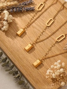 Close-up of three 18k gold plated stainless steel necklaces with LOVE bar pendants