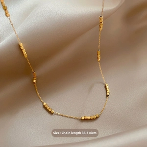 Detail view of gold beaded geometric necklace showing 38.5cm plus 6cm extension chain