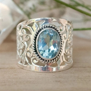 Anello largo traforato vintage con gemma blu ovale e intricati motivi floreali