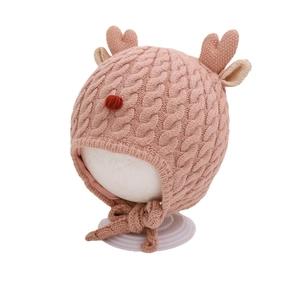 Cute pink baby winter knit hat with antlers and earflaps in classic cable knit pattern