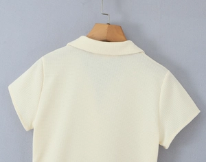 Detailaufnahme des cremefarbenen Polokragens und der Waffelstrick-Struktur am Kleid