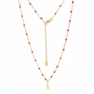 Detail of gold feather pendant and red rice beads on a polished stainless steel chain
