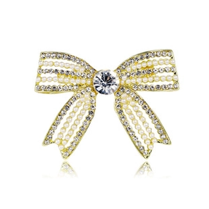 Detailed close-up of bow knot brooch with gold metal, pearls, and sparkling crystals