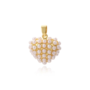 Détail d'un pendentif cœur avec finition dorée et perles incrustées sur fond blanc