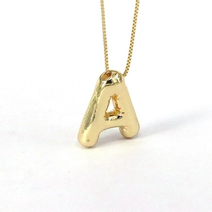 Golden puffy letter A pendant necklace for women with a polished shiny finish on white background