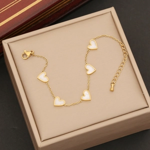 Detailed macro view of heart-shaped shell pendants on a golden stainless steel chain