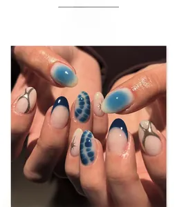 Macro view of blue marble almond press-on nails with silver glitter and star accents