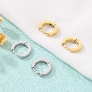 Detailed view of polished gold and silver hoop earrings with snap-lock closure mechanism