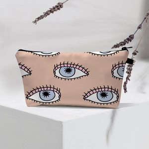 Detail of waterproof Evil Eye makeup bag with blue patterns on a beige surface
