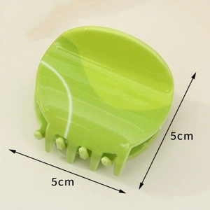 Green tennis ball hair claw clip with white lines measuring 5cm in diameter