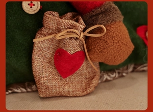 Macro detail of burlap pouch with red heart patch and wooden button on festive cushion