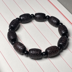 Macro view of Ebony wood barrel beads with exquisite carved cloud patterns and spacers