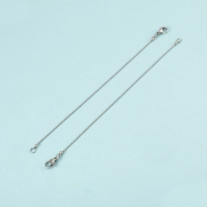 Detail of two silver ball chain bracelets with lobster clasps on a blue background