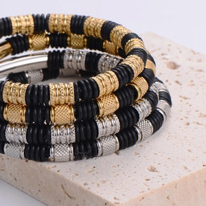 Stacked men's stainless steel bracelet with gold and silver knurled beads and black rubber rings
