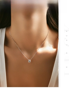 Close-up of s925 sterling silver necklace with teardrop zircon pendant on female neck