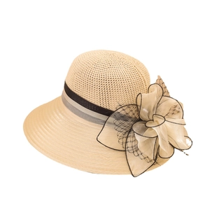 Elegant beige straw sun hat featuring a large layered ribbon bow for beach vacation