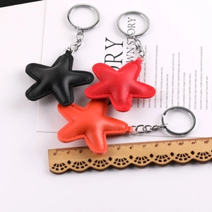 Detailed view of colorful leather star pendants with metallic rings beside a wooden ruler