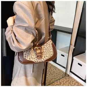 Détail du sac léopard avec bandoulière en cuir marron et boucle décorative
