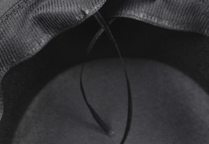 Close-up of the interior sweatband and adjustable drawstring in a black wool hat.