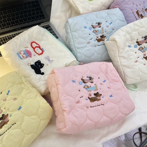 Detail van gewatteerde make-up tassen met schattig borduurwerk en ritssluiting
