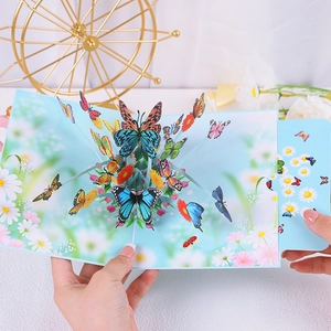 Detailed close-up of 3D pop-up greeting card featuring blue butterflies and daisies