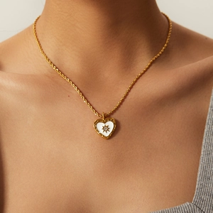 Elegante collar con colgante de corazón dorado, esmalte blanco y detalle de estrella