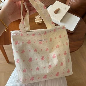 Detailaufnahme der floralen Canvas-Tasche mit rosa Blumenmuster und gewebtem Stoffetikett