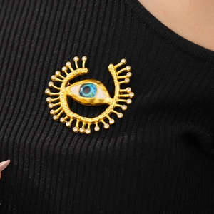 Detail of vintage evil eye brooch with blue resin iris and sparkling crystal rhinestones