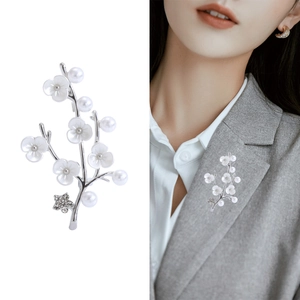 Silver flower branch brooch with white pearls and rhinestones on a grey suit jacket