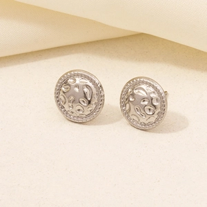 Detailed macro view of silver hammer-textured round stud earrings with rope border edge