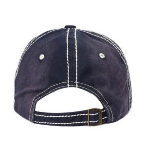 Détail d'une casquette en coton délavé bleu foncé avec coutures et boucle métallique