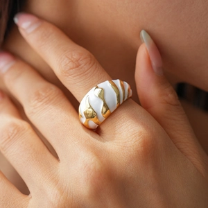 Macro shot of wide spiral ring featuring two-tone silver and gold enamel finish